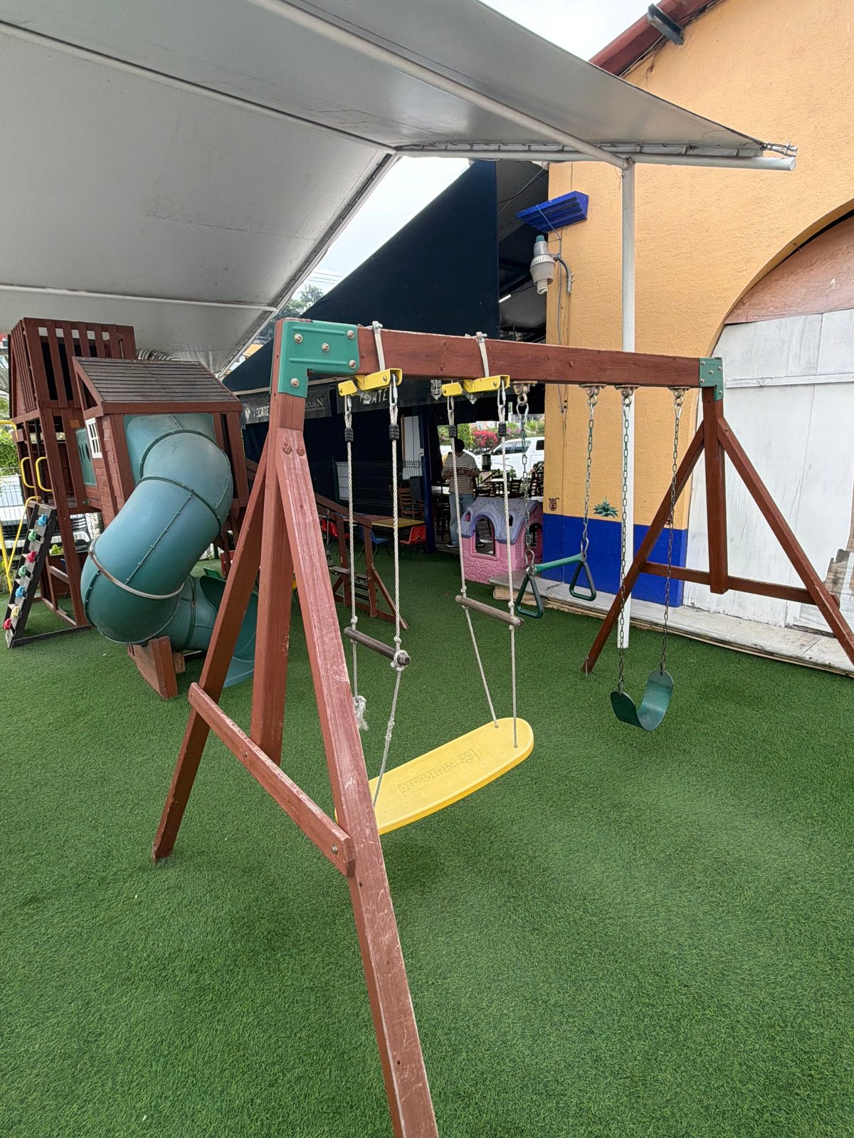 Columpio amarillo y juegos de madera en el área de niños de Tecuán